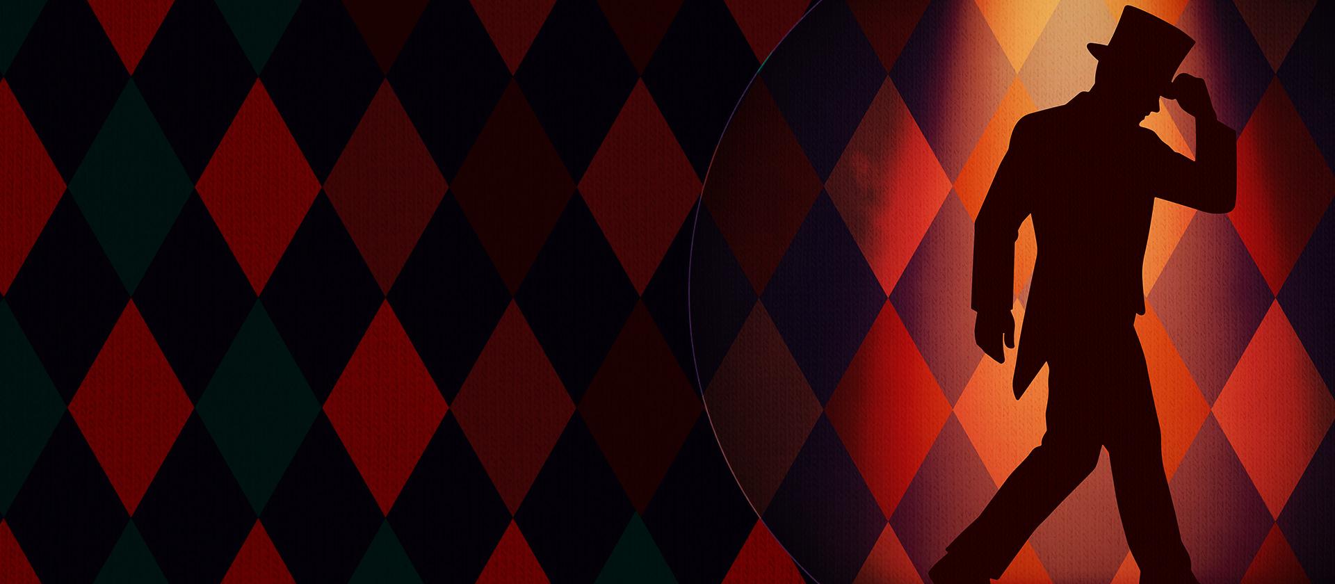 A man in a tuxedo and top hap stands in shadow in front of a diamond checked background with a spotlight shining on him.